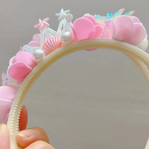 Detail eines Kinderhaarbands mit bunten Muscheln Perlen und rutschfesten Zähnen