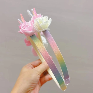 Detail eines glitzernden Regenbogen-Haarreifens mit 3D-Blumen für Kindergeburtstage