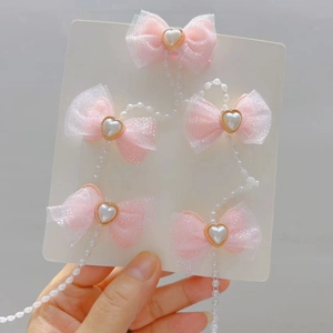 Rosa Mesh-Haarspangen-Set mit herzförmigen Perlen auf einer weißen Displaykarte
