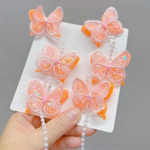 Détail de 6 pinces à cheveux papillon rose avec chaînes de perles et broderies fines