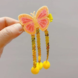 Barrette papillon pailletée pour filles avec pampilles dorées et pompons jaunes doux
