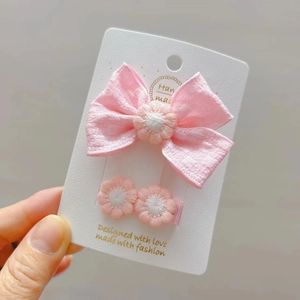 Set di fermagli per capelli con fiocco in tessuto rosa e dettagli a margherita