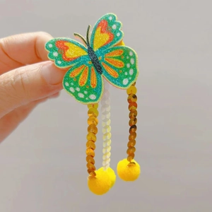 Barrette papillon scintillante avec sequins colorés, pompon jaune et glands dorés