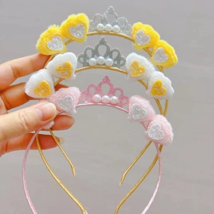 Close-up of three plush heart headbands with glitter crowns and faux pearls for kids