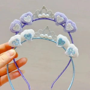 Macro detail of plush heart headbands featuring silver glitter crowns and white pearls