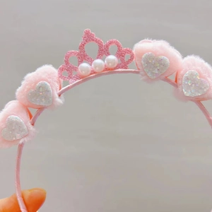 Detailed close-up of pink plush headband featuring glitter crown and imitation pearls