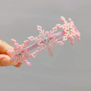 Gros plan sur le serre-tête flocon de neige rose pailleté avec strass brillants au centre