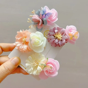Detail van handgemaakte vlinder haarclip met strass en roze stoffen bloemen