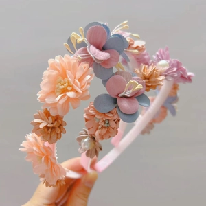 Détail d'un serre-tête floral avec fleurs en tissu multicouches et perles nacrées