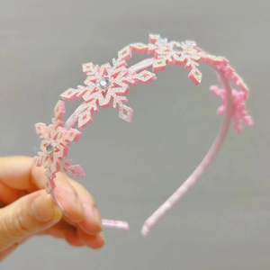 Gros plan du serre-tête rose avec flocons scintillants et strass pour filles