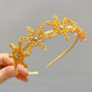 Vue détaillée du serre-tête flocon doré avec strass et finition ruban satiné