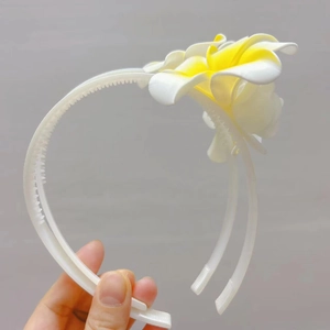 Détail du serre-tête blanc à fleurs avec dents antidérapantes pour une tenue parfaite