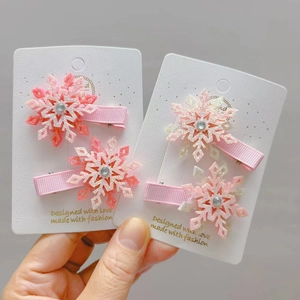Détail des barrettes à cheveux flocon de neige à paillettes avec strass sur carte
