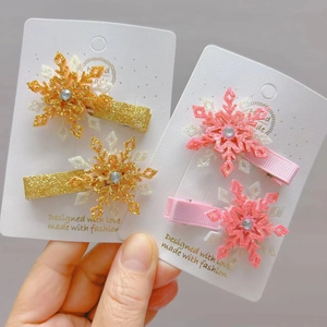 Détail de barrettes flocon de neige pailletées avec strass sur carte de présentation