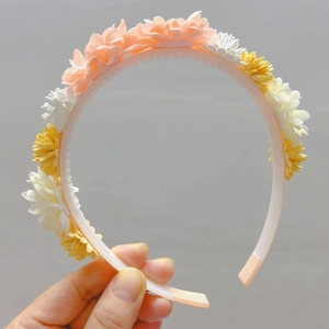 Détail d'un serre-tête floral avec marguerites roses et dents antidérapantes sûres