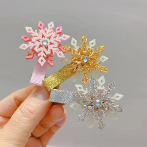 Gros plan détaillé de barrettes flocons de neige pailletées avec strass en rose, or et argent