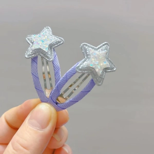 Close-up of sparkling star hair clips for kids with purple fabric and glitter sequins