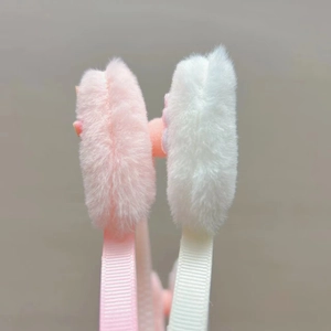Détail de serre-têtes oreilles de chat en fausse fourrure rose et blanche avec ruban doux