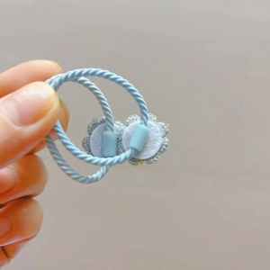 Détail d'élastiques à cheveux tissés bleu clair avec décoration délicate en dentelle