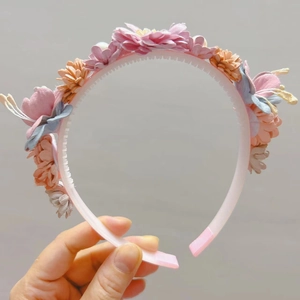 Détail des dents antidérapantes et des fleurs en tissu colorées sur le serre-tête fille