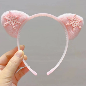 Détail d'un serre-tête oreilles de chat rose en peluche avec flocons pailletés et dents antidérapantes