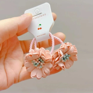 Paire d'élastiques à cheveux en tissu fleuri rose avec centre perlé sur carte