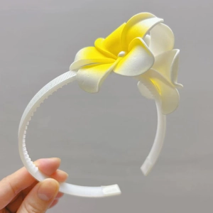 Vue détaillée du serre-tête avec fleurs de frangipanier aux pétales blancs et dégradé jaune
