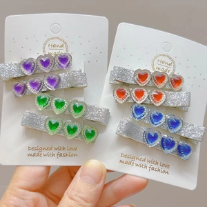 Detail of colorful heart gem hair clips with sparkling silver glitter coating finish