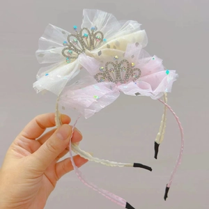 Dettaglio di cerchietti con fiocchi in rete e corone di strass in crema e rosa