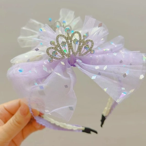 Dettaglio cerchietto per bambina con fiocco in rete viola e corona d'argento scintillante