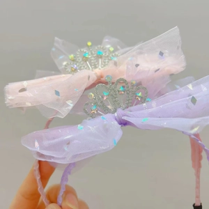 Dettaglio di cerchietti in tulle rosa e viola con corone di strass argentati per bimba