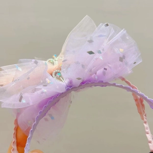 Dettaglio cerchietto in tulle sfumato viola e rosa con corona e paillettes argento