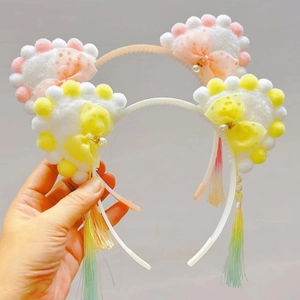 Detail of plush cat ear headbands with mesh bows, faux pearls and gradient tassels