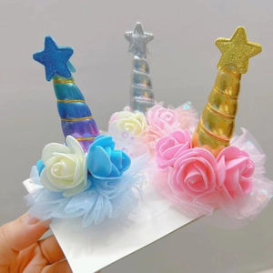 Detail of glitter unicorn horn hair clips with tulle lace and colorful foam roses