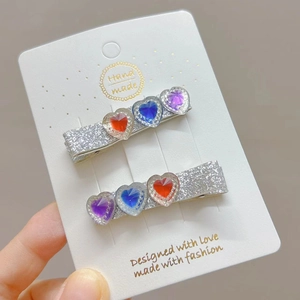 Close-up of glitter hair clips with colorful heart rhinestones on handmade display card