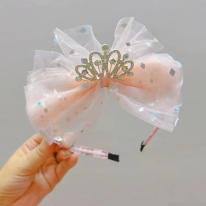 Dettaglio della fascia in tulle rosa con corona di strass per bambine