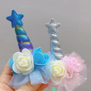Detail showing two unicorn hair clips with glitter stars, fabric roses and mesh net