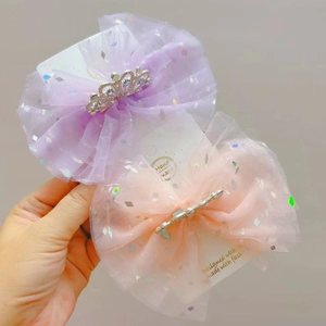 Dettaglio di fiocchi per capelli in mesh glitterato con corone di strass viola e rosa