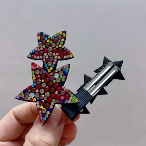 Detailed macro view of colorful rhinestone star hair clips with metal duckbill fastener
