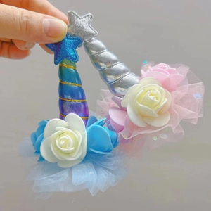 Detail of unicorn hair clip featuring glitter stars, spiral horn, and mesh skirt decor