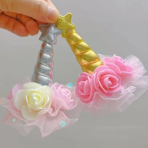 Detailed view of handmade unicorn hair clips featuring glitter stars and pink faux roses