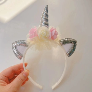 Detailed view of silver unicorn horn headband with pink roses and non-slip white base