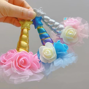 Detail of colorful unicorn horn hair clips with mesh lace and glitter stars for party wear