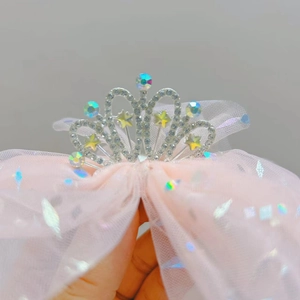 Dettaglio del cerchietto a corona in tulle rosa con strass e stelle per bambine