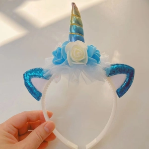 Detail of unicorn headband with blue glitter ears and colorful faux rose flowers