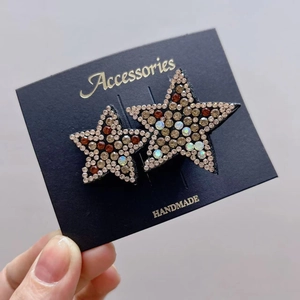 Detail of star-shaped hair accessories with sparkling multi-colored rhinestones and black base