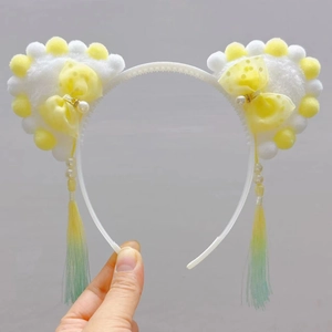 Detailed view of cat ear headband with pearl tassels and yellow polka dot bow