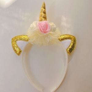 Unicorn headband with golden horn, pink flower, and sequins for party role play