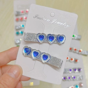 Close-up of blue heart rhinestone hair clips with sparkling gems on fashion display card