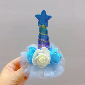 Close-up of unicorn hair clip with blue sequins star, foam roses and tulle mesh details